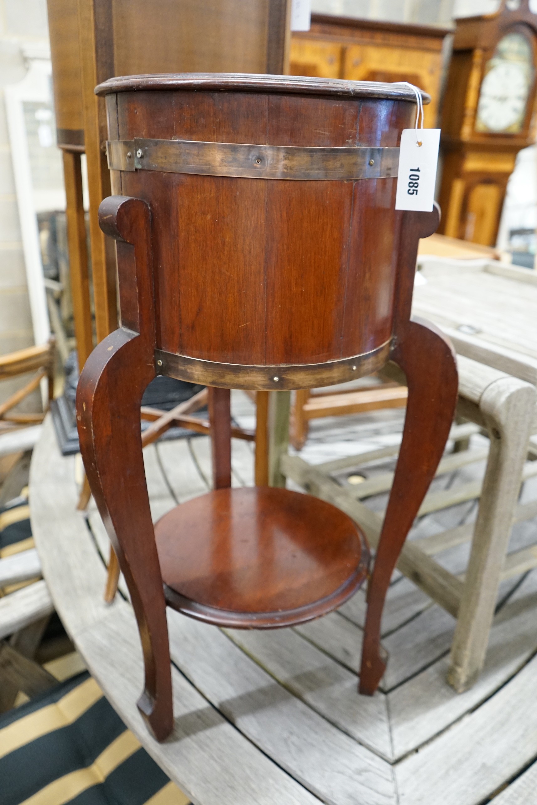 An Arts and Crafts brass bound staved mahogany circular jardiniere, diameter 35cm, height 78cm